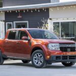 An orange 2022 Ford Maverick is shown from the front at an angle after leaving a dealer that has used cars for sale.