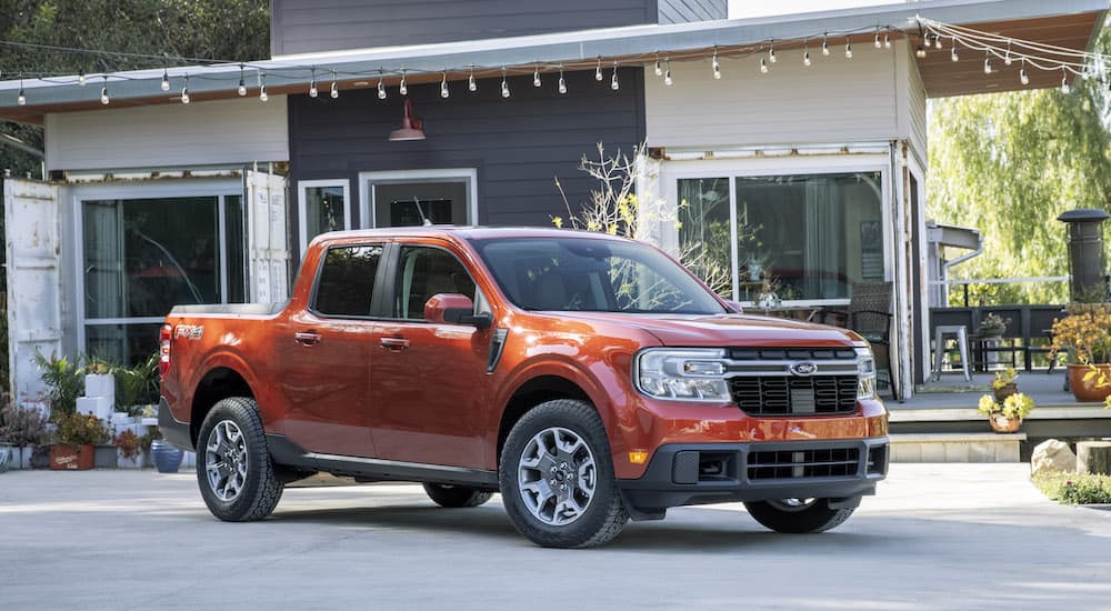 An orange 2022 Ford Maverick is shown from the front at an angle after leaving a dealer that has used cars for sale.