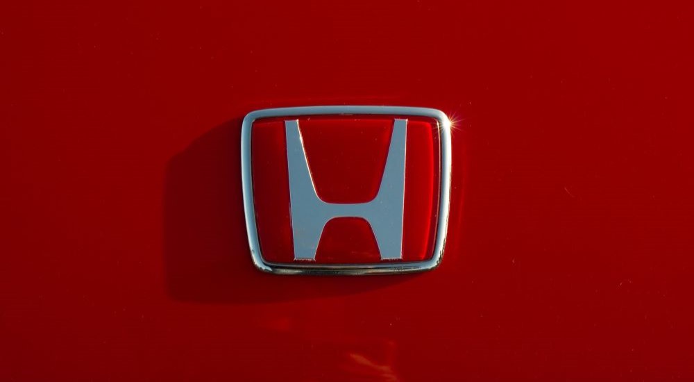 A silver and red Honda badge on a red background.