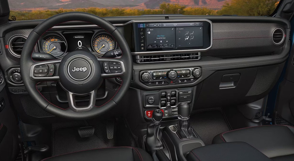 The black interior of a 2024 Jeep Gladiator for sale is shown from the drivers seat.