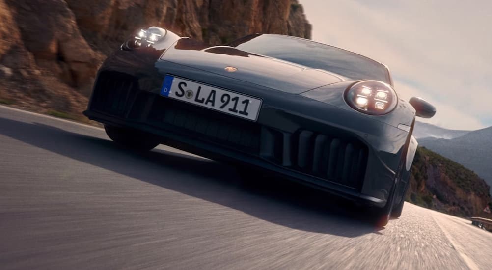 A close-up of the grille on a gray 2025 Porsche 911 Carrera GTS Hybrid is shown.