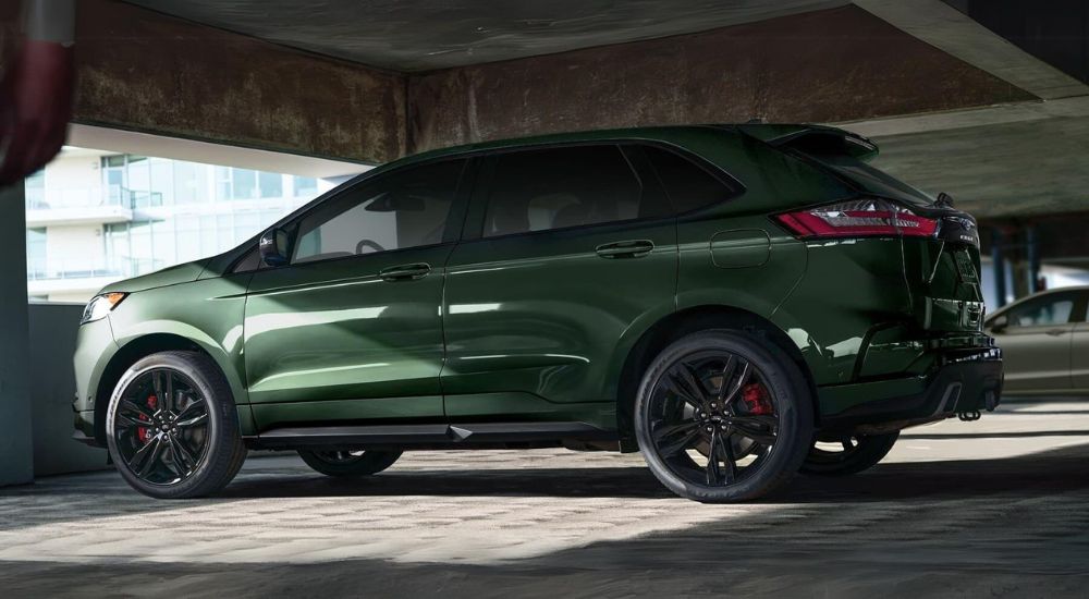 Side view of a forest green 2023 Ford Edge parked in a garage.