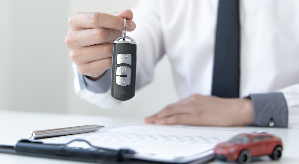 A salesman is shown holding a key fob.