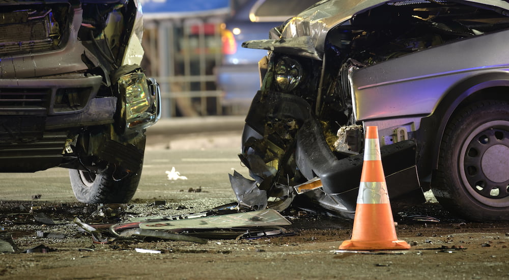 A close-up on the hoods of two severely damaged cars after a collision.