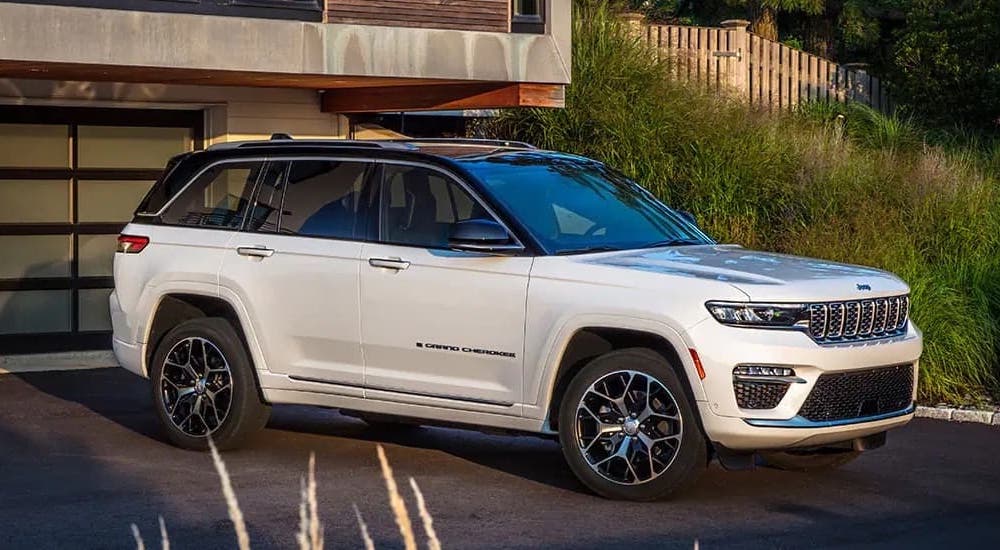 A white 2023 Jeep Grand Cherokee is shown from the side.