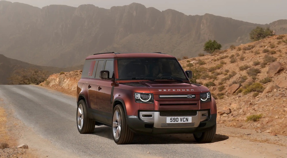 A red 2023 Land Rover Defender is shown from the front at an angle.