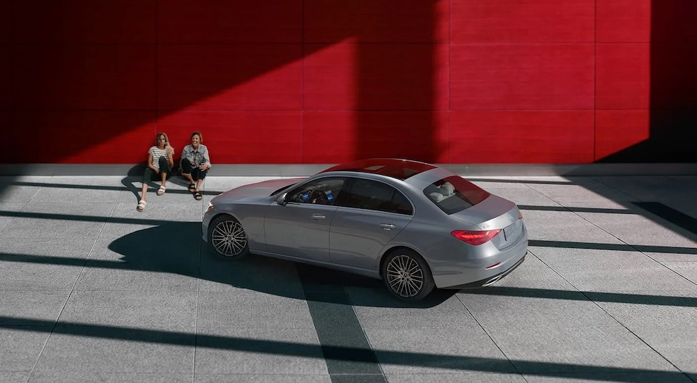 A silver 2024 Mercedes-Benz C-Class is shown from the rear at an angle.