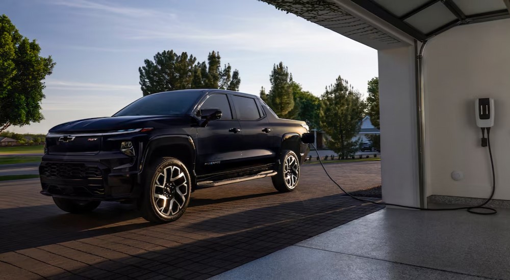 A black 2024 Chevy Silverado EV RST is shown charging.