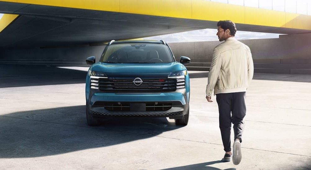 A teal 2025 Nissan Kicks SR is shown parked near a person walking.