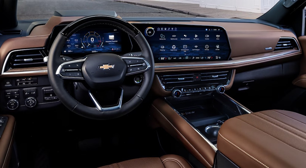 The brown interior of a 2025 Chevy Tahoe High Country is shown from the driver's seat.