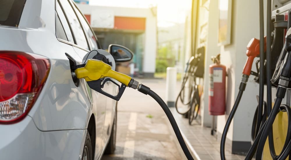 A car is shown parked at a gas pump.