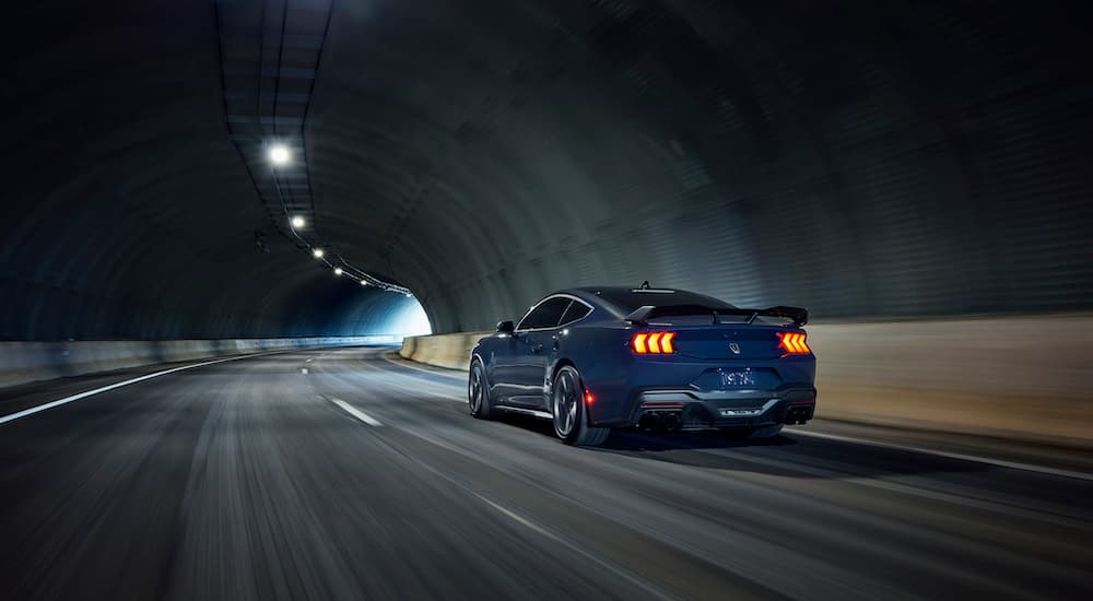 A blue 2024 Ford Mustang Dark Horse is shown from the rear at an angle.