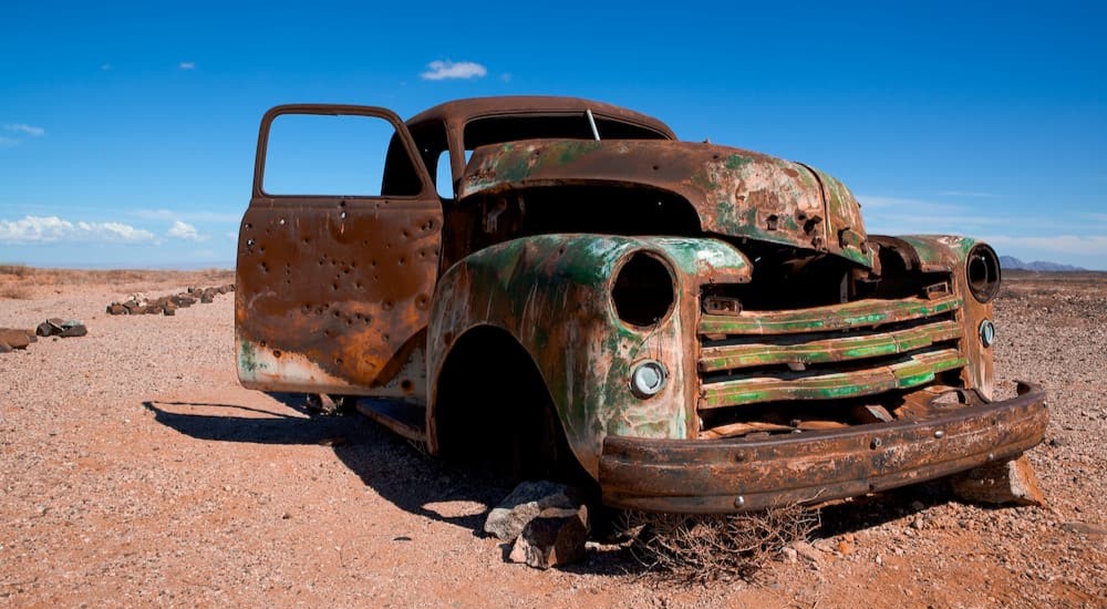 A broken old truck is shown in the desert.