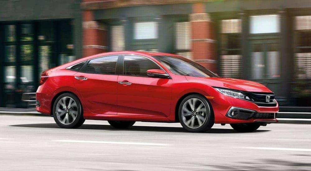 A red 2020 Honda Civic Sedan Touring is shown from the side after leaving a used car dealer.