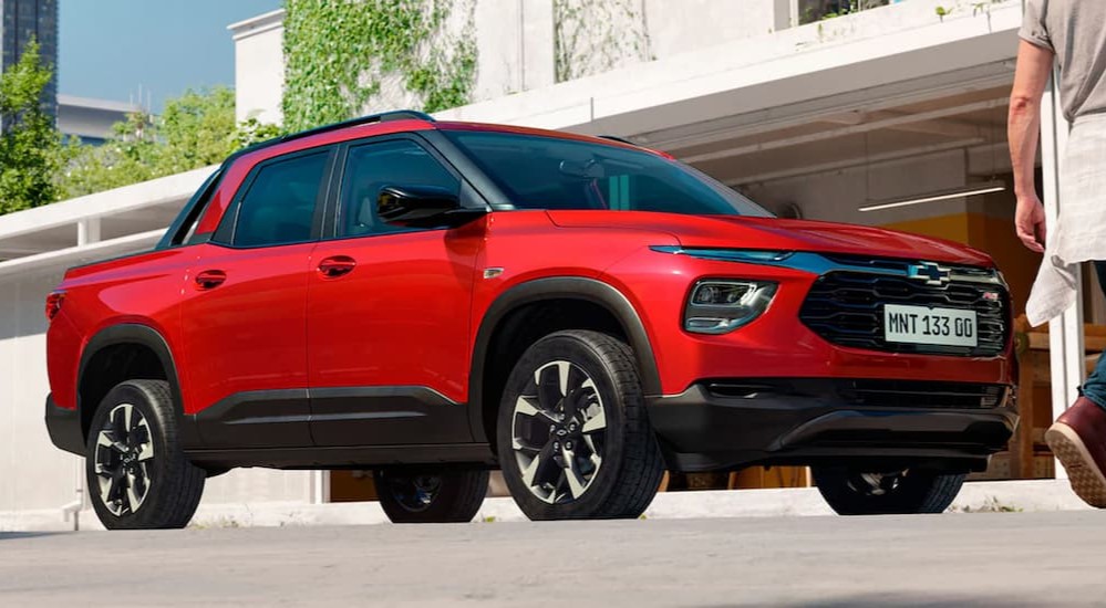 A red 2023 Chevy Montana RS is shown parked near a house.