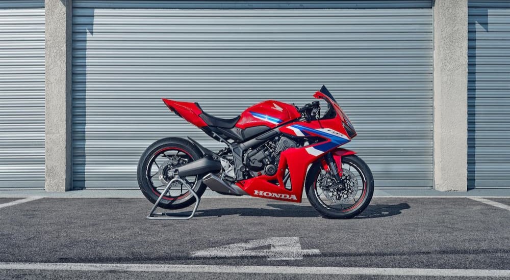 A red 2024 Honda CBR650R is shown parked on a stand.