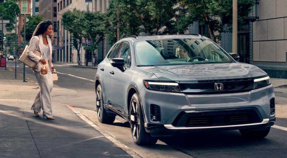 A silver 2024 Honda Prologue Elite is shown parked near a curb.