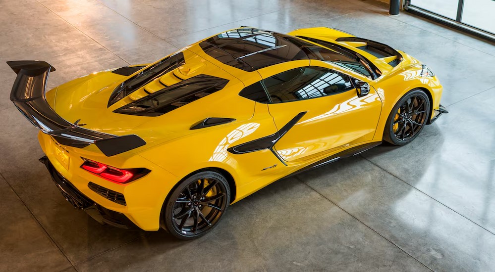 A yellow 2025 Chevy Corvette ZR1 is shown parked on a showroom floor.