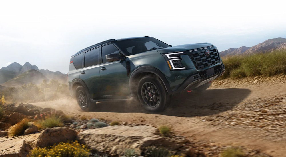 A green 2025 Nissan Armada PRO-4X is shown driving off-road after visiting a Nissan dealer.