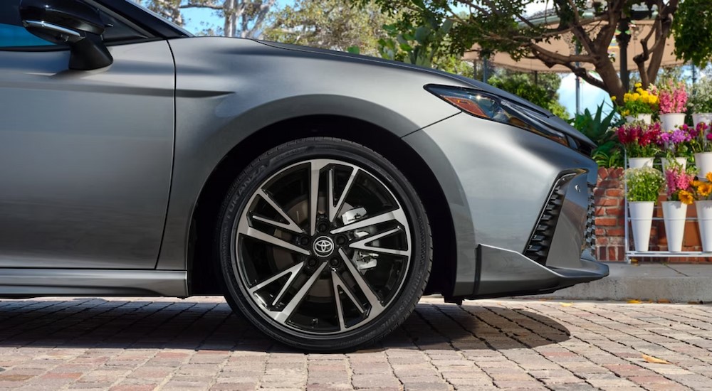 A close-up of a wheel is shown on a silver 2025 Toyota Camry.