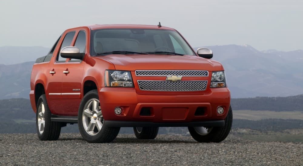 A red 2011 Chevy Avalanche is shown parked off-road.