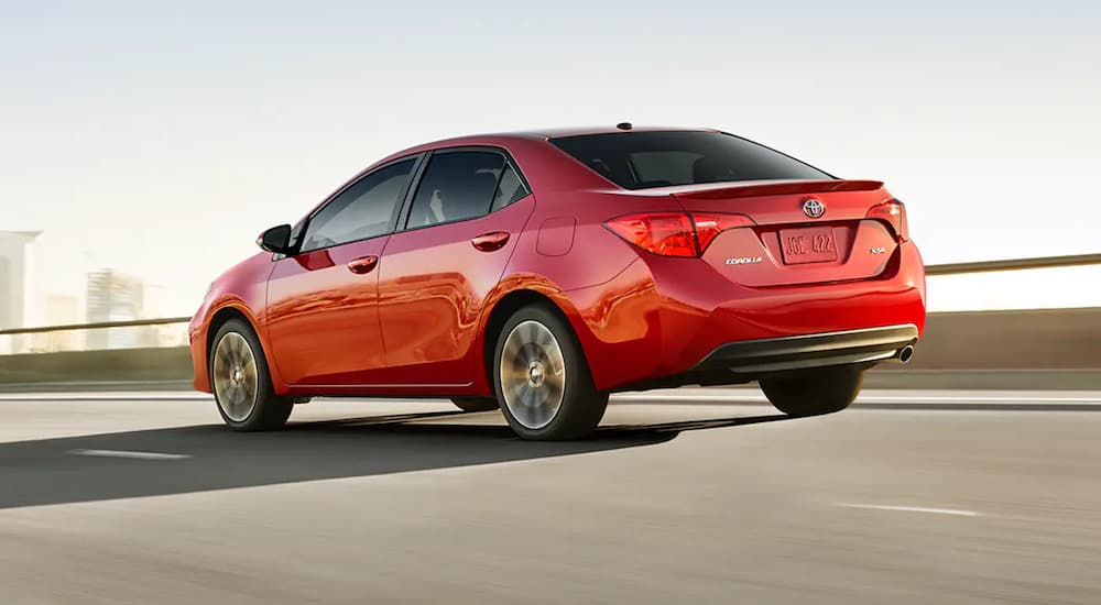 A red 2019 Toyota Corolla is shown driving on a highway.