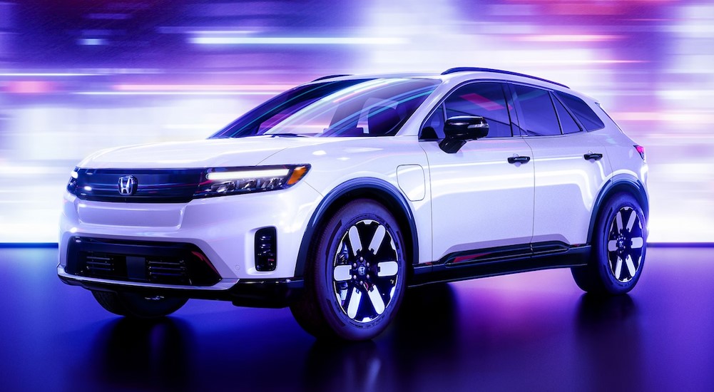 A white 2024 Honda Prologue is shown parked in a colorful showroom.