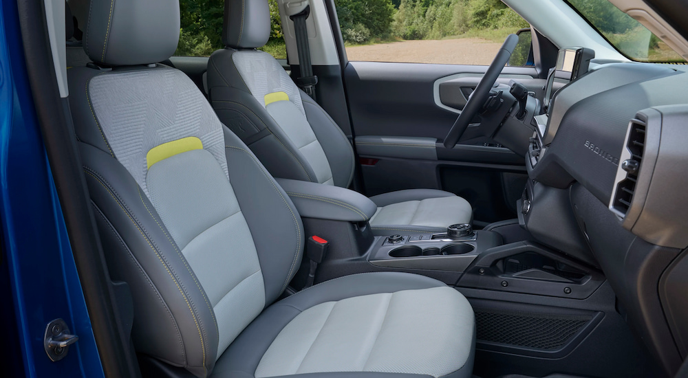 The front seats inside a 2025 Ford Bronco Sport Badlands Sasquatch at a dealer with cars for sale.