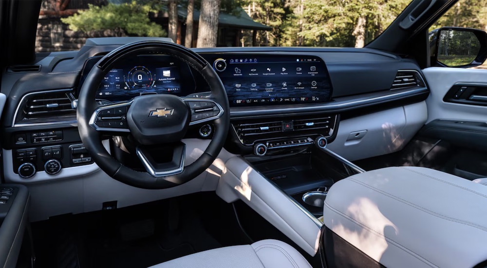 The black and white interior cabin and steering wheel of a 2025 Chevy Tahoe for sale.