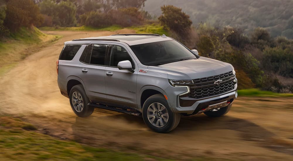 A grey 2025 Chevy Tahoe Z71 driving off-road on a trail.