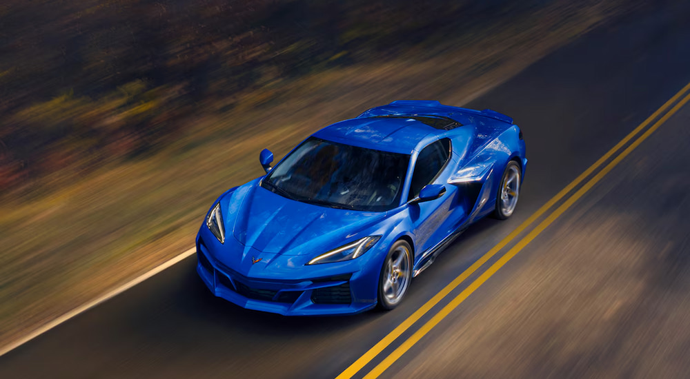 Overhead view of a blue 2024 Chevy Corvette E-Ray driving on a highway.