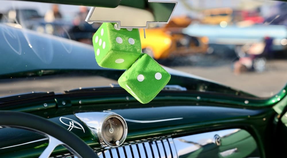 Green fuzzy dice are shown hanging from a mirror.