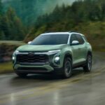 A green 2025 Chevy Equinox ACTIV is shown driving on a wet highway.