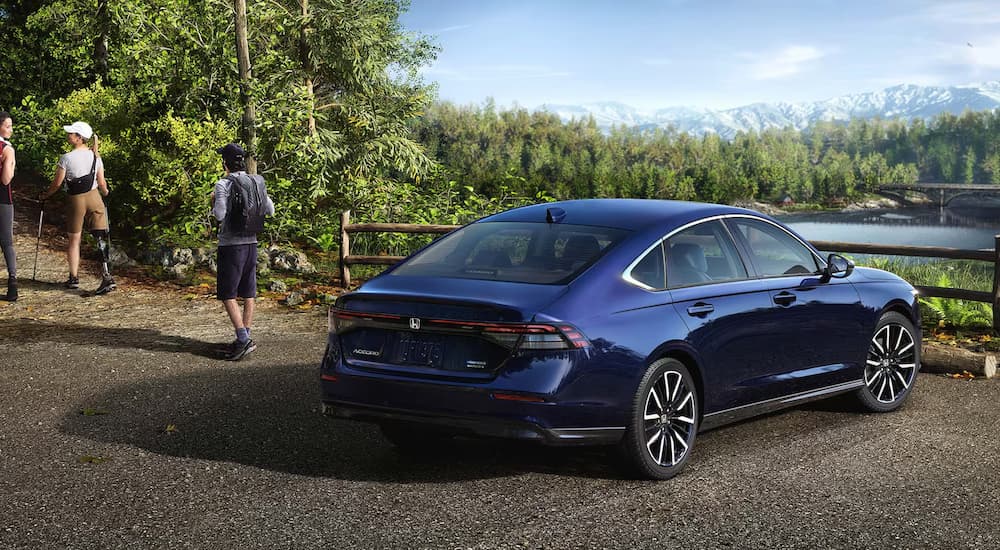 Rear angle view of a parked blue 2025 Honda Accord Touring Hybrid.