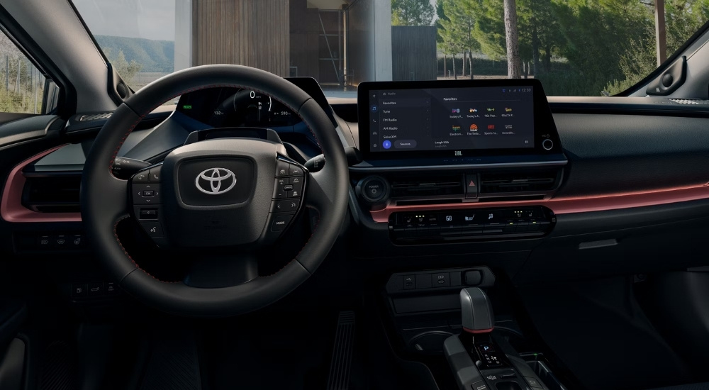 The steering wheel and infotainment screen in a 2025 Toyota Prius Plug-In XSE Premium at a Toyota dealer.