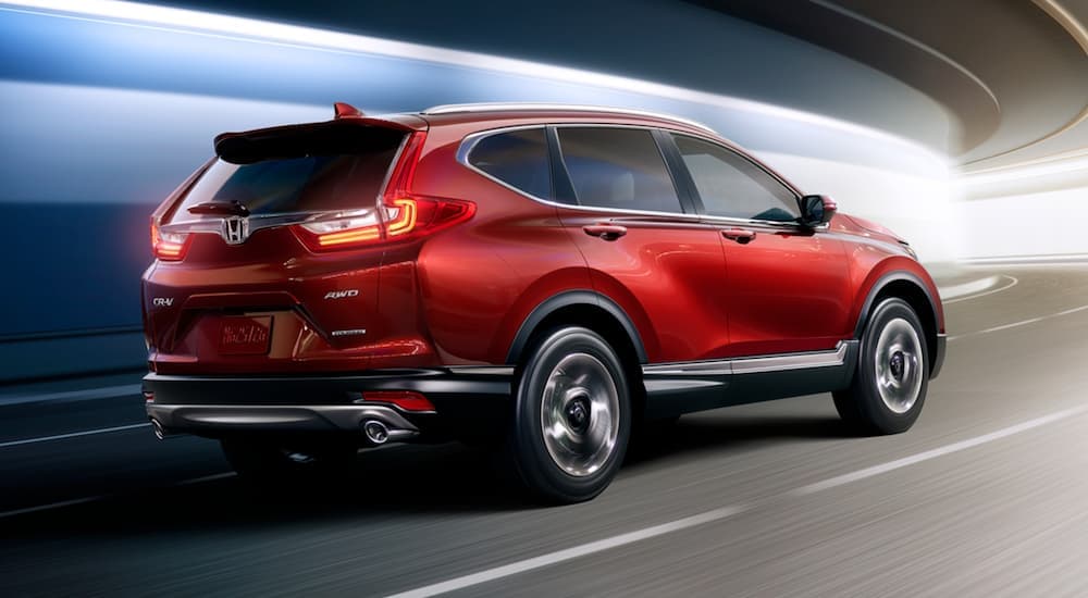 Rear angle view of a red 2017 Honda CR-V driving through a tunnel.