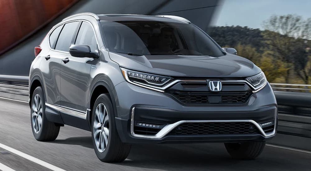 A grey 2022 Honda CR-V Hybrid Touring driving across a bridge.