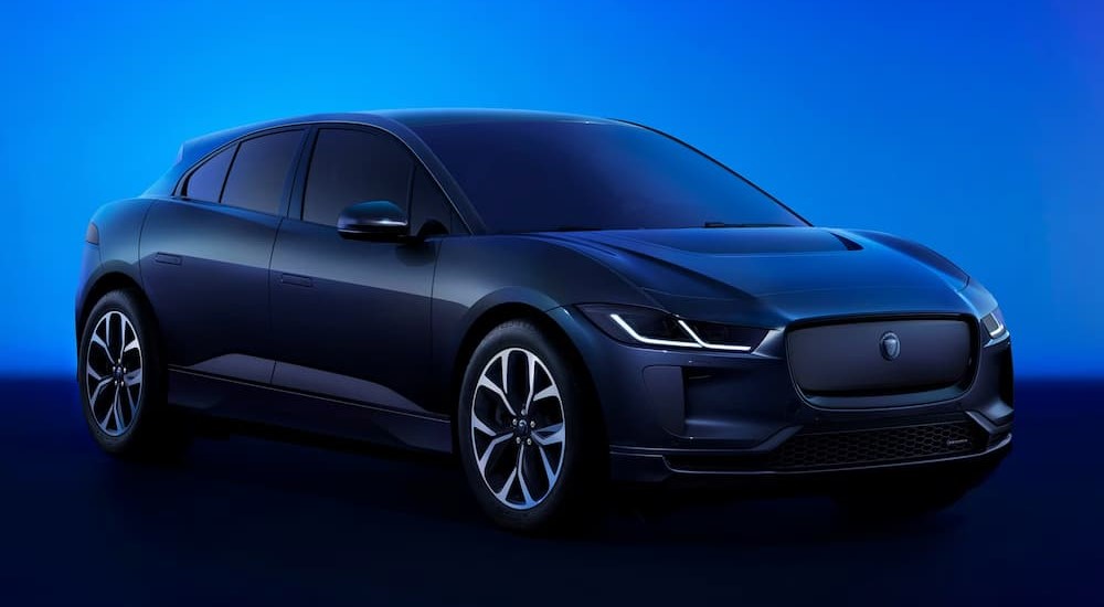 A blue 2024 Jaguar I-PACE R-Dynamic HSE is shown parked in a blue lit room.