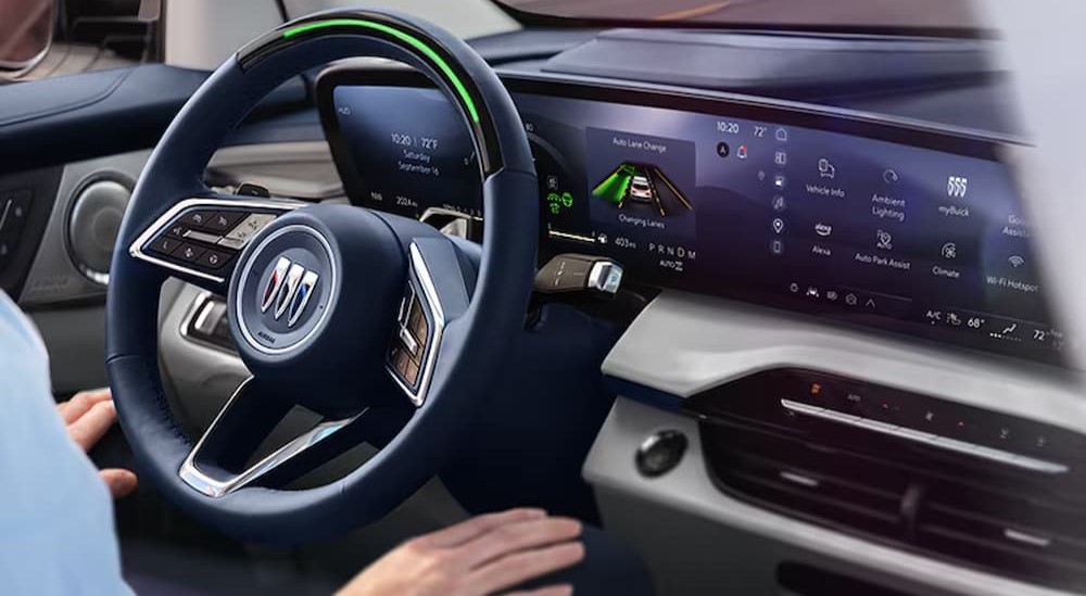 A close-up of the steering wheel and dash is shown in a 2025 Buick Enclave for sale.