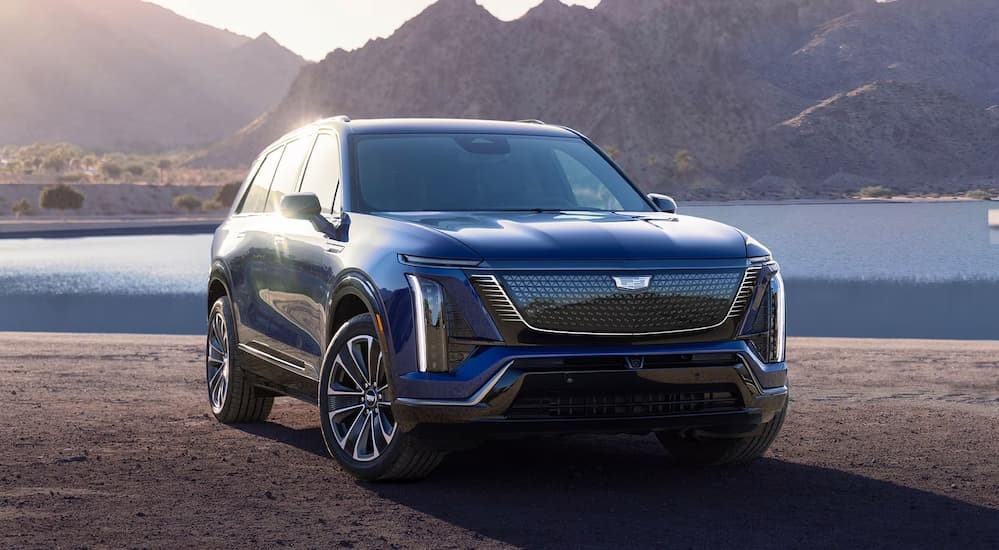 A blue 2026 Cadillac VISTIQ is shown parked near a lake.