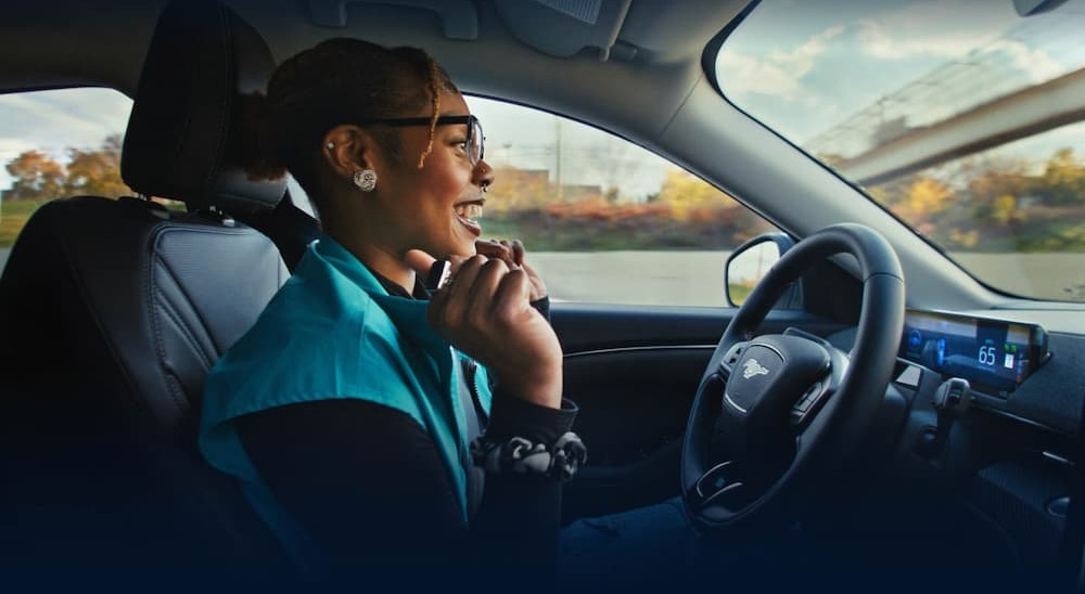 A person is shown driving hands-free in a 2024 Ford Mustang Mach-E.