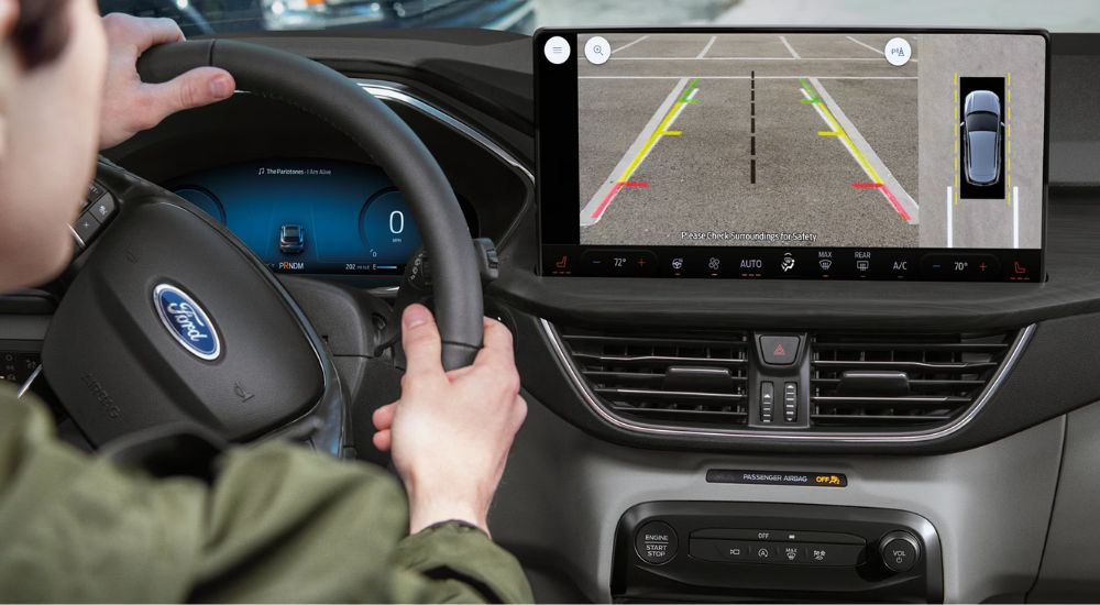 A driver using the 360-Degree Camera view on a 2025 Ford Escape for sale.