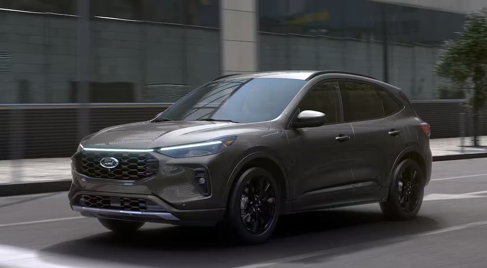 A grey 2025 Ford Escape driving on a city street.