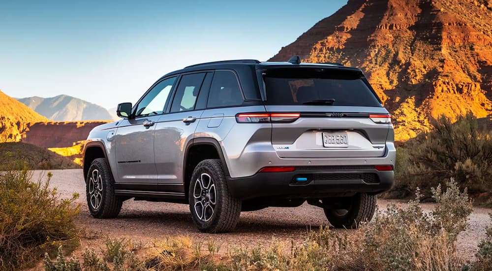 Rear view of a silver 2025 Jeep Grand Cherokee L for sale parked off-road.