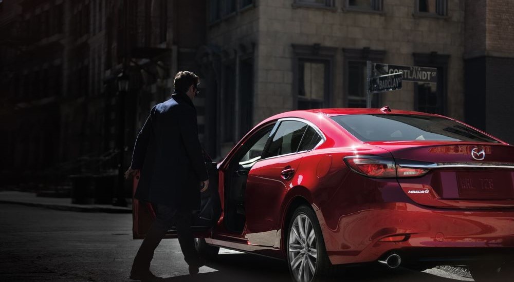 A person is shown entering a red 2019 Mazda6.