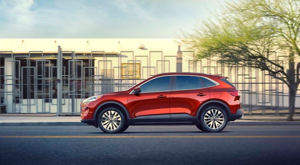 A red 2020 Ford Escape is shown driving on a city street.