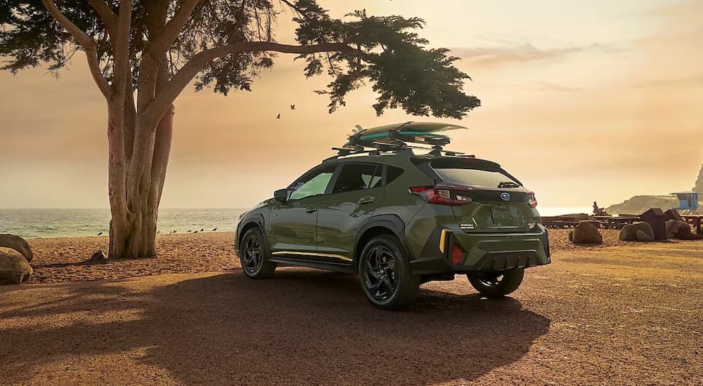 A green 2024 Subaru Crosstrek is shown from the rear at an angle.