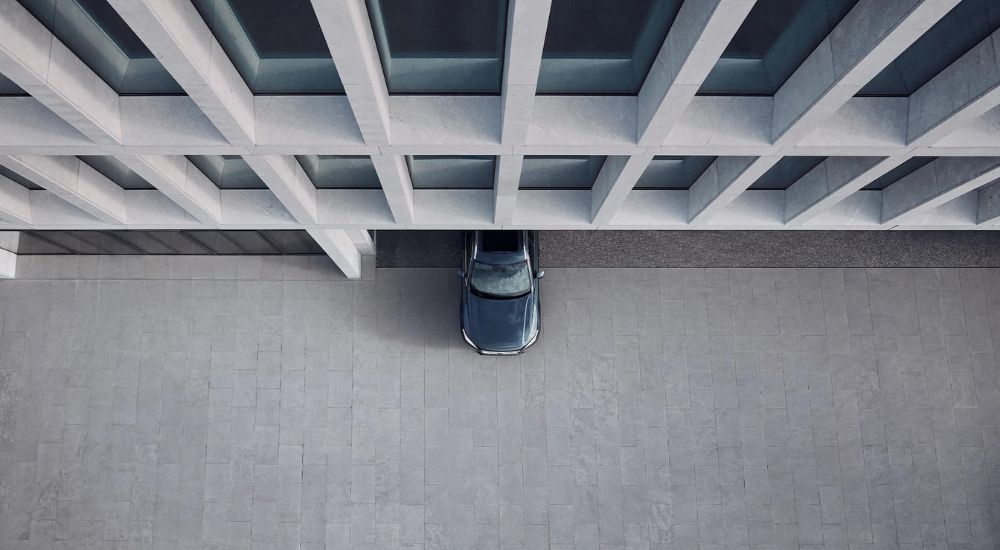 A top down view of a blue 2024 Volvo XC90 is driving out of a parking garage.