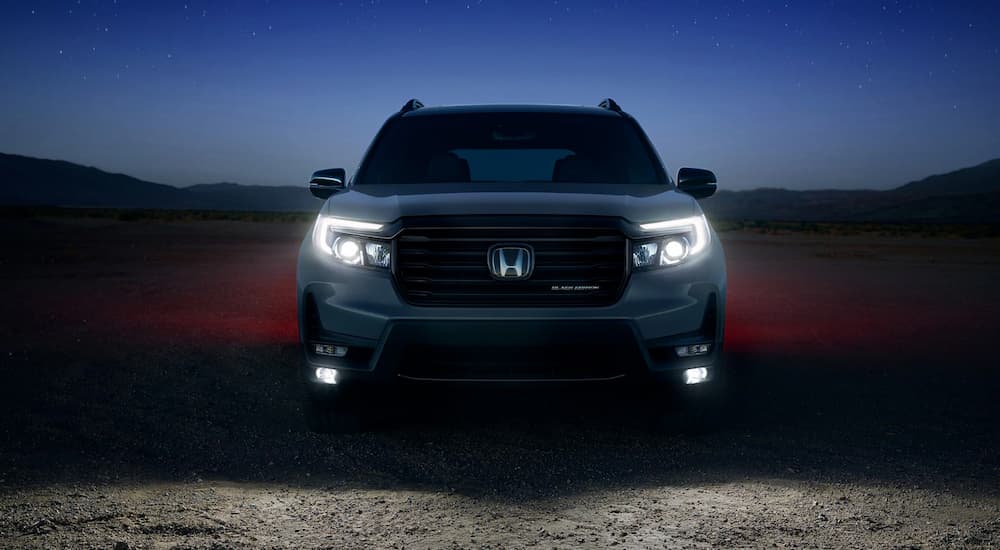 Front view of a grey 2025 Honda Passport TrailSport parked at night.