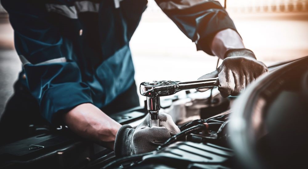 A close-up shows a mobile mechanic working on a vehicle. 